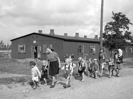 Historisches Foto einer Gruppe von Kindern mit Betreuerinnen in einem Lager für deutsche Flüchtlinge in Oxböl, Dänemark, 1948.