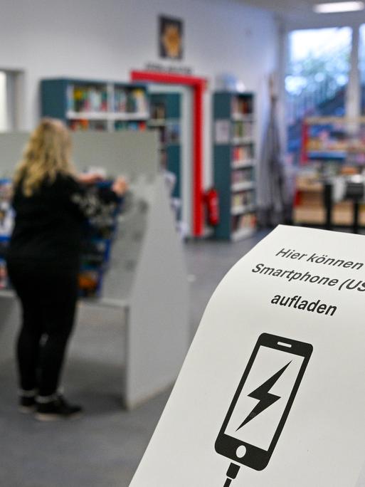 Die Gottfried-Benn-Bibliothek bietet Menschen im Gebiet ohne Strom die Möglichkeit, Smartphones zu laden. Zu sehen ist ein Aushang mit einem Hinweis darauf. 