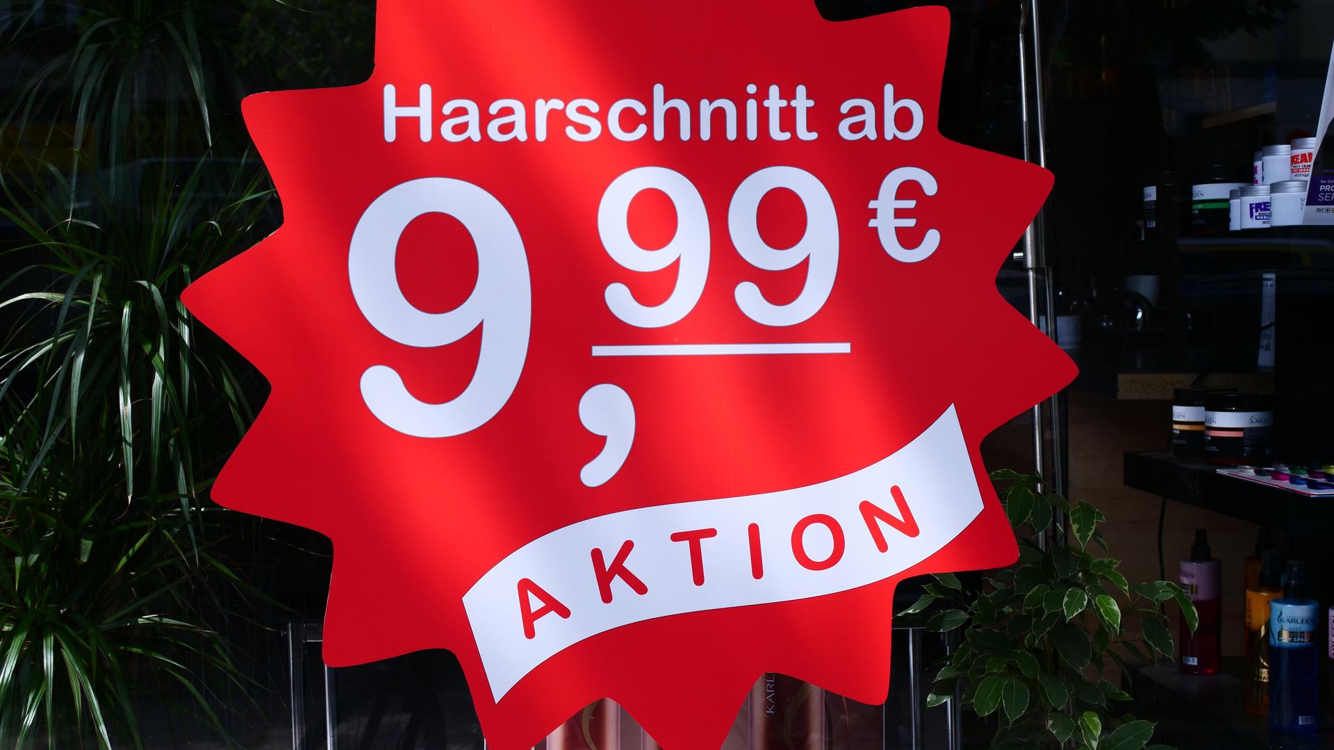 Ein Schild wirbt an einem Friseurladen mit der Aufschrift "Haarschnitt ab 9,99 Euro".