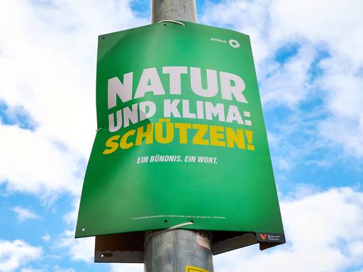 Das Wahlplakat der Grünen hängt an einer Straßenlaterne: "Natur und Klima: Schützen!"