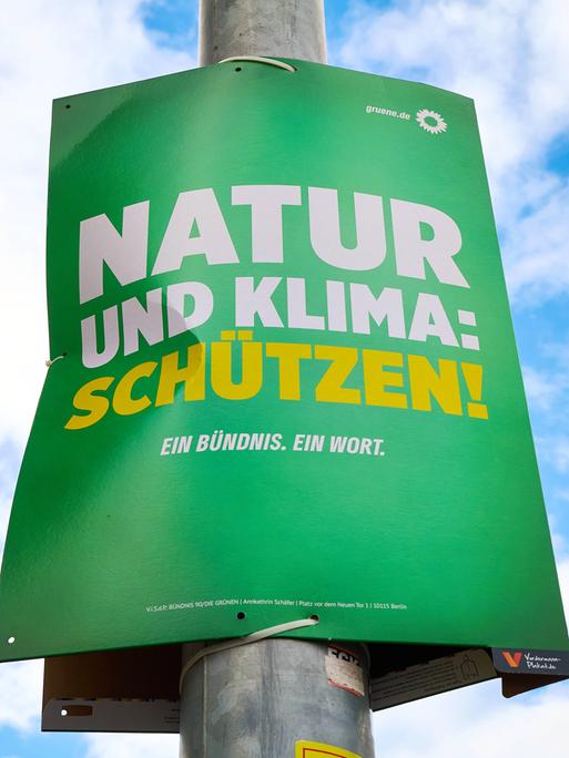 Das Wahlplakat der Grünen hängt an einer Straßenlaterne: "Natur und Klima: Schützen!"