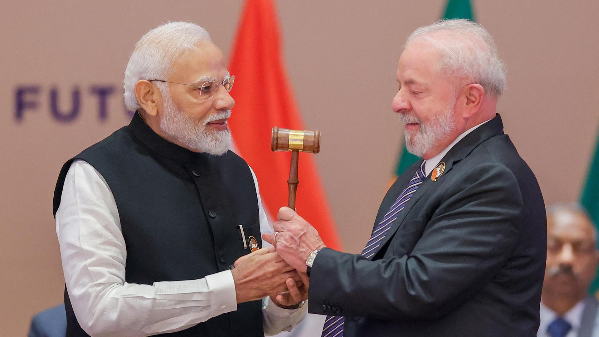Indiens Präsident Narendra Modi (l.) übergibt Brasiliens Präsident Luiz Inacio Lula da Silve (r.) einen Konferenzhammer.