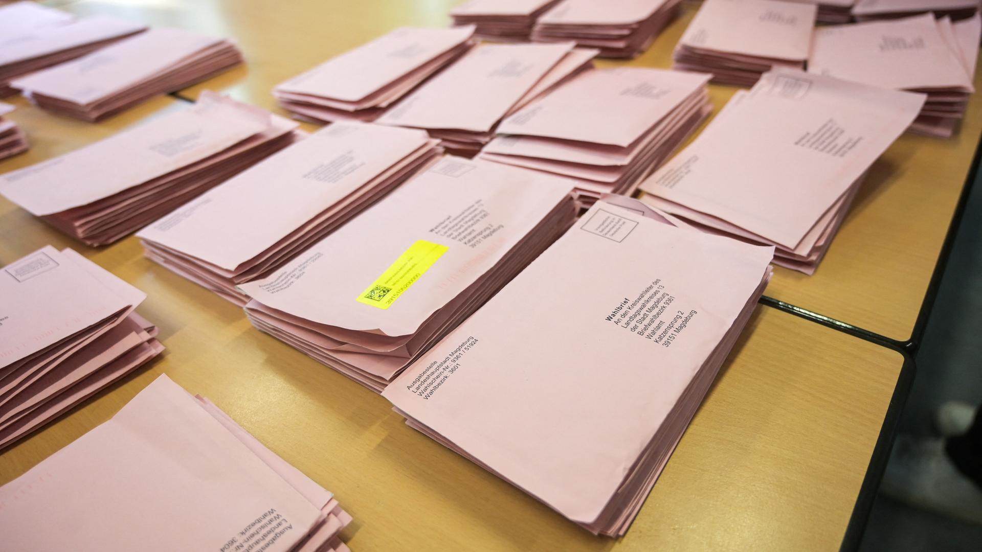 Briefwahlumschläge für die Landtagswahl in Sachsen-Anhalt liegen auf einem Tisch. 