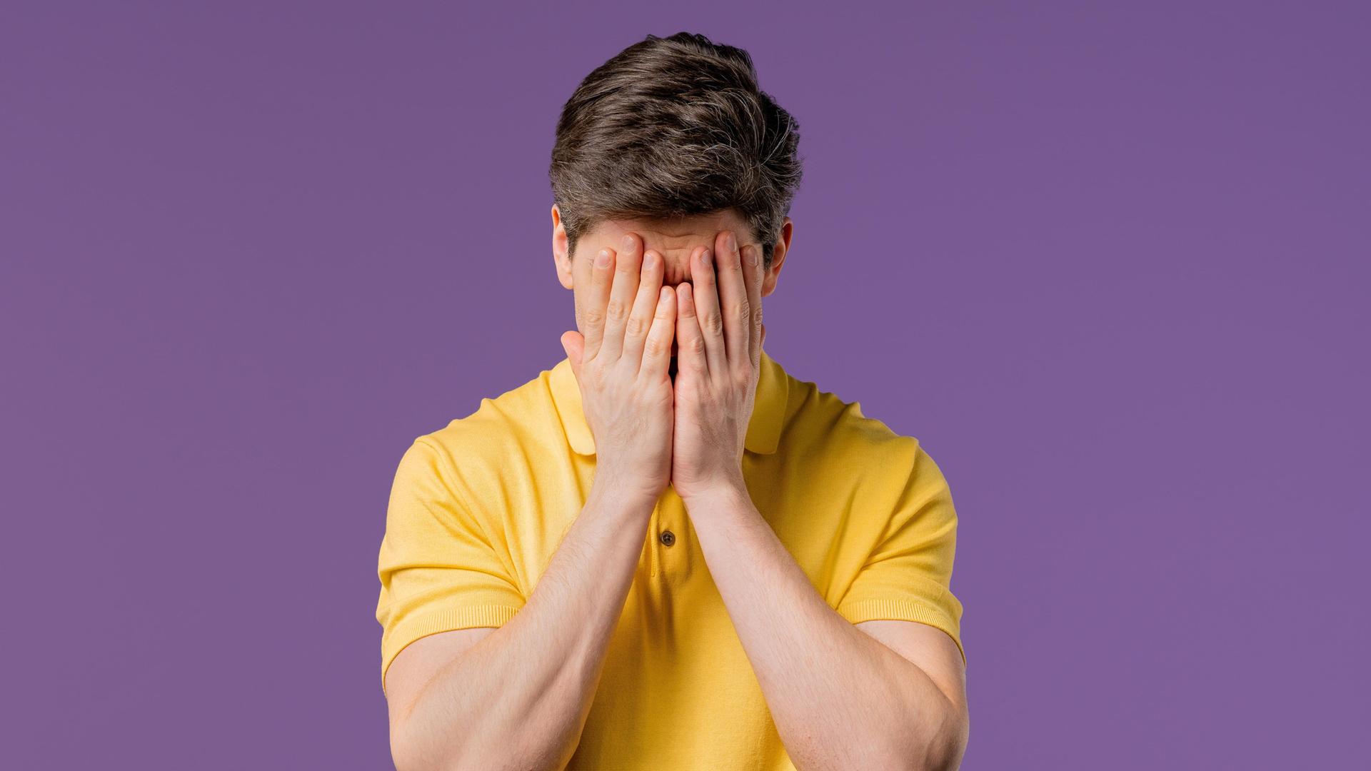 Ein weinender Mann, er trägt ein gelbes Poloshirt und hält die Hände vor den Kopf (Symbolbild) Ein weinender Mann, er trägt ein gelbes Poloshirt und hält die Hände vor den Kopf (Symbolbild)