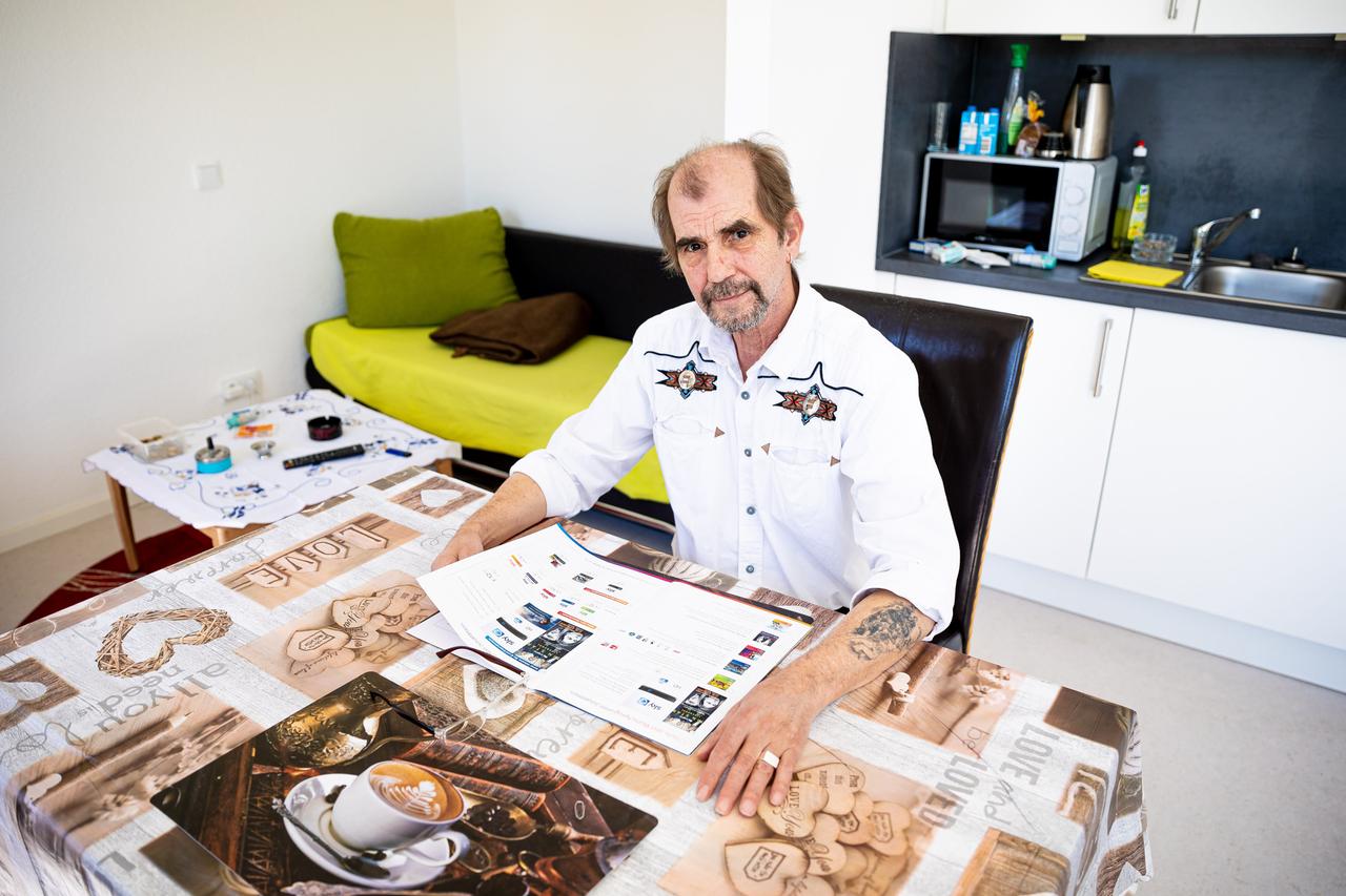 Der ehemalige Obdachlose Franz-Konrad Bauer sitzt in seiner Wohnung, an die er über das Obdachlosen-Projekt Â«Housing firstÂ» gelangt ist, und liest in einer Zeitschrift.