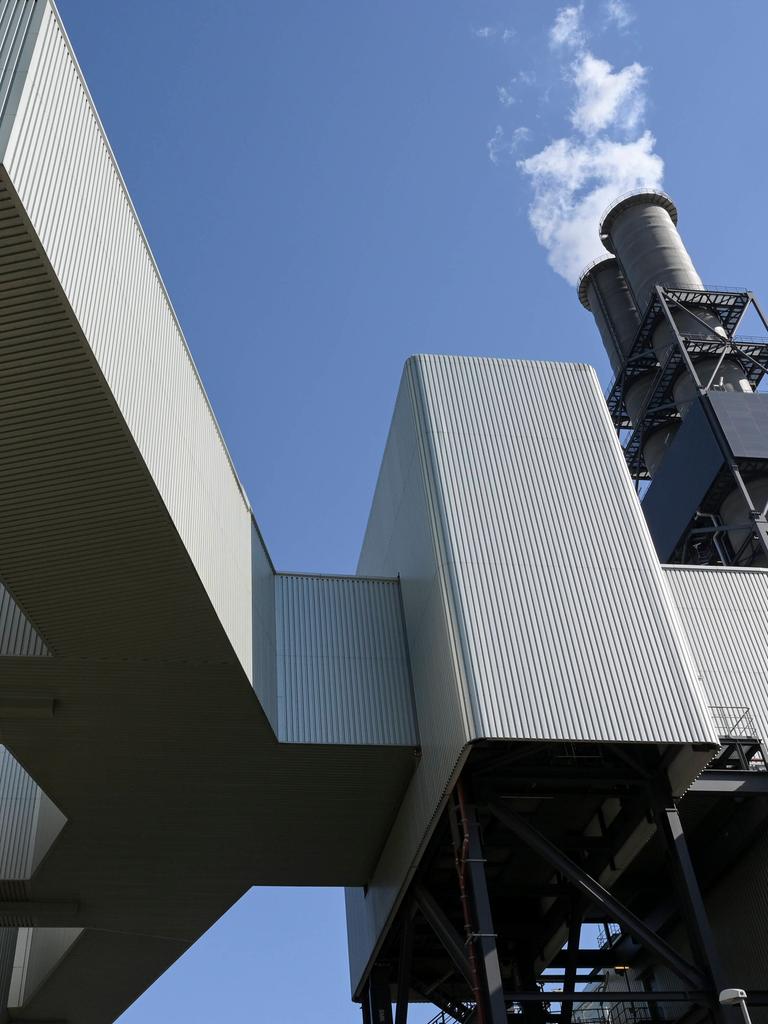 Ein Kühlturm ragt über einer komplexen Industrieanlage hervor. Ein Kühlturm ragt über einer komplexen Industrieanlage hervor.