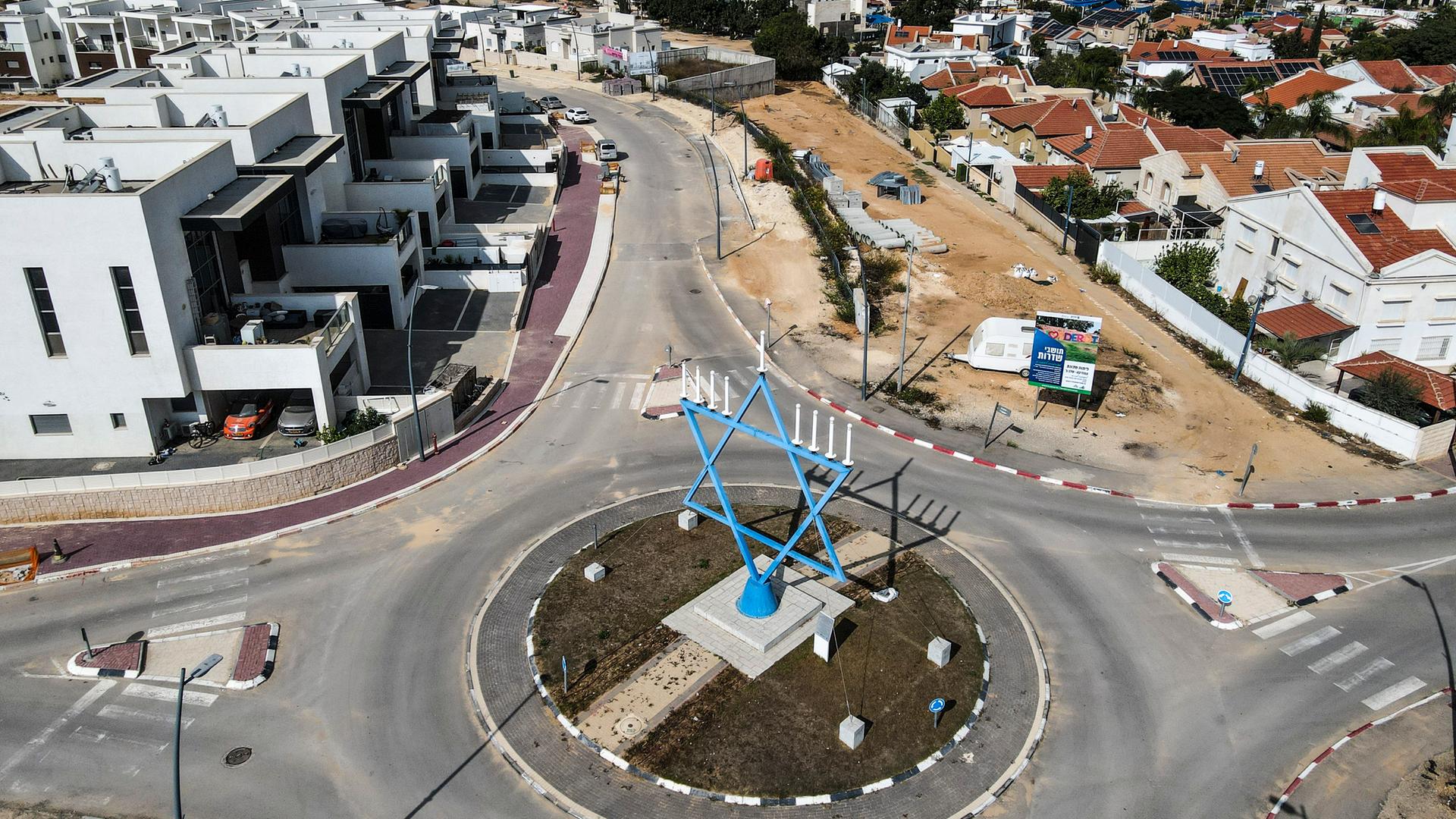 Leere Straßen in Sderot - Blick auf einen Kreisverkehr in dessen Mitte ein großer blauer Davidstern, versehen mit 7 weißen Kerzen, steht. Leere Straßen in Sderot - Blick auf einen Kreisverkehr in dessen Mitte ein großer blauer Davidstern, versehen mit 7 weißen Kerzen, steht.