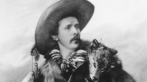 Porträt von Karl May in der Verkleidung des Old Shatterhand mit einem toten Fuchs über der Schulter.