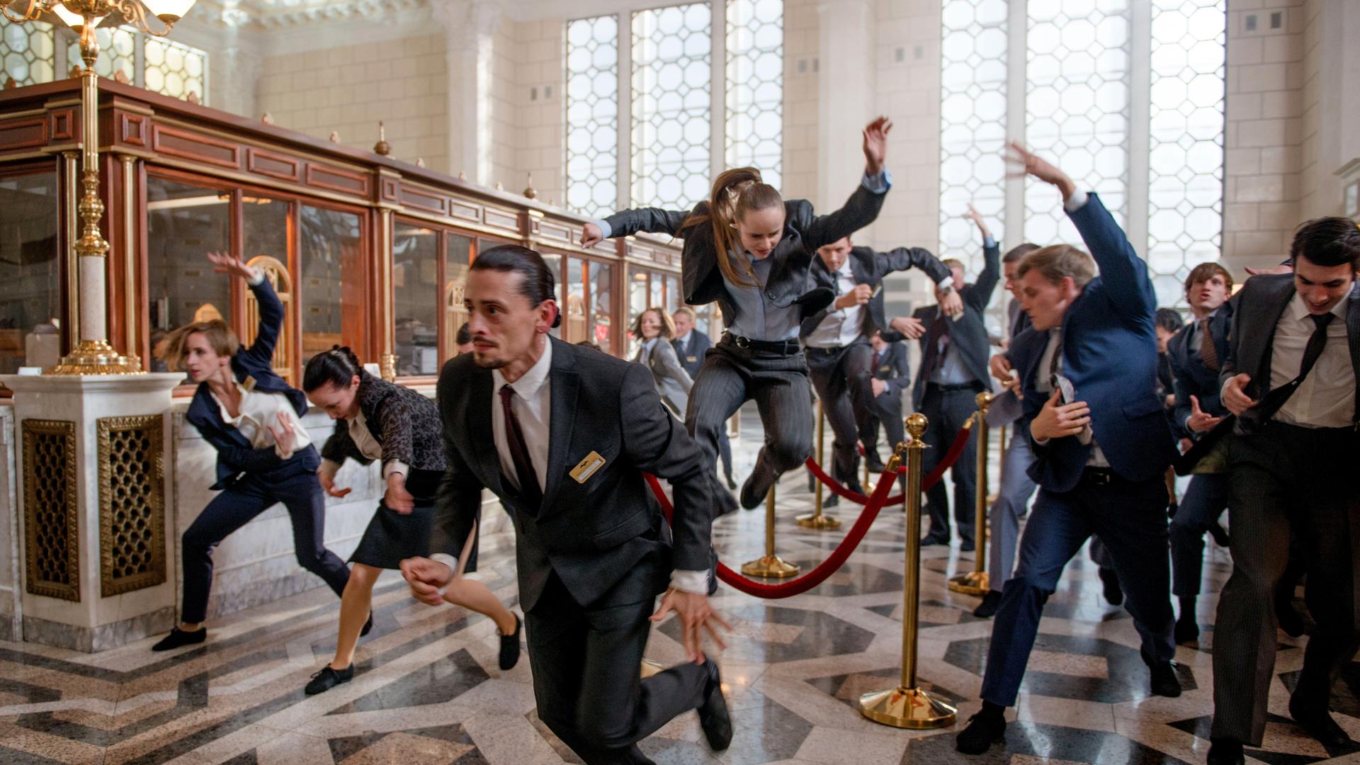 Ausschnitt aus der Videoinstallation "EUPHORIA": Bankangestellte tanzen wild im Foyer der Bank.
