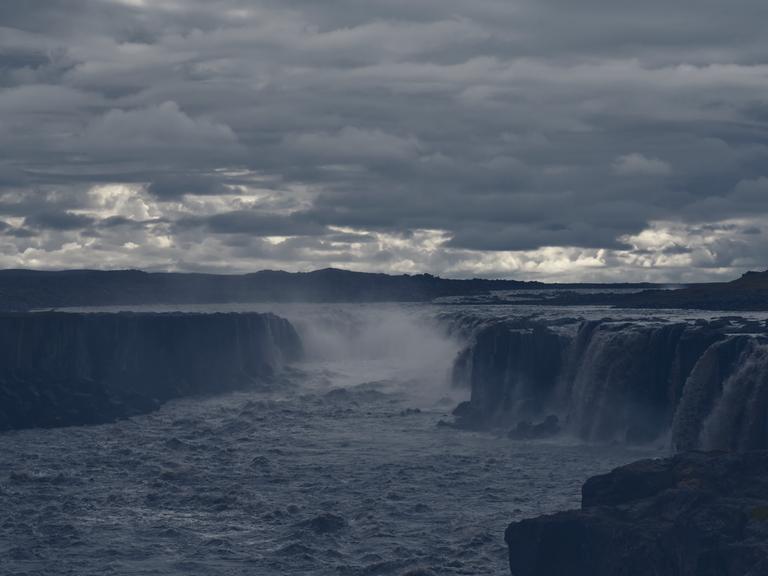 Der Wasserfall Hafragilsfoss in Gischt und Nebel, aufgenommen im August 2021. Darüber bricht die Sonne ganz leicht durch die Wolken. Der Wasserfall Hafragilsfoss in Gischt und Nebel, aufgenommen im August 2021. Darüber bricht die Sonne ganz leicht durch die Wolken.