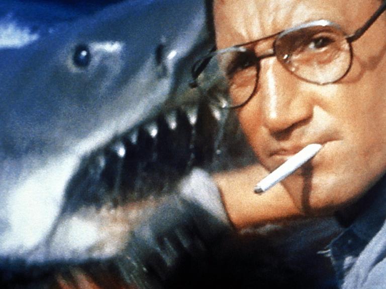 Auf dem Bild ist der Schauspieler Roy Scheider zu sehen, der im Film "Der weiße Hai" den Polizeichef Martin Brody spielt, dahinter der titelgebende Hai. Der Film von Steven Spielberg kam am 20. Juni 1975 in die US-Kinos