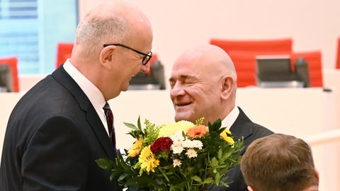 Dietmar Woidke (M), Ministerpräsident von Brandenburg, und Robert Crumbach (BSW), Abgeordneter im Landtag von Brandenburg, übergibt Woidke einen Strauß Blumen. 