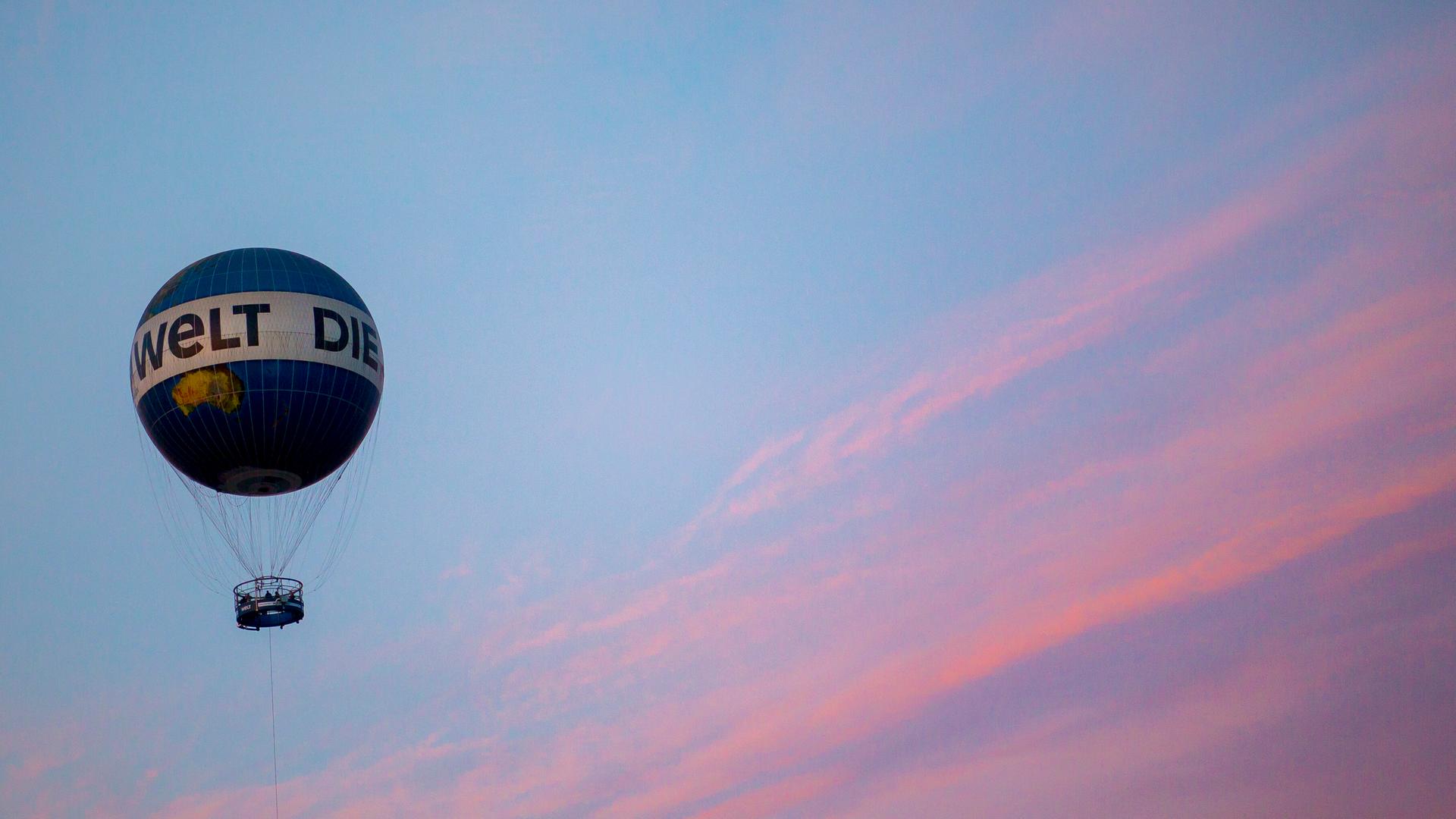 Der Heißluftballon der Zeitung "Die Welt" schwebt im Sonnenuntergang über Berlin.