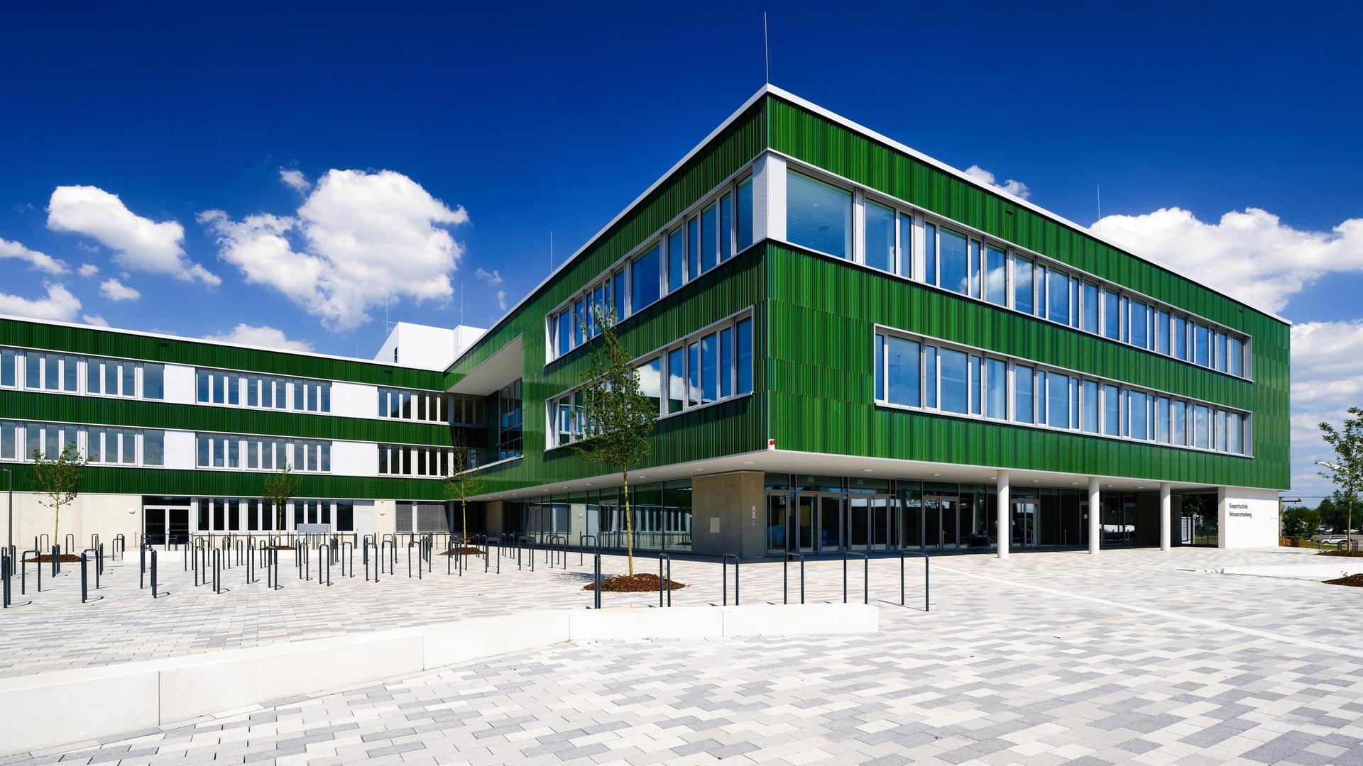 Ein fast fertiggestellter Neubau einer Gesamtschule im Kölner Stadtteil Vogelsang bei sonnigem Wetter im Mai 2024