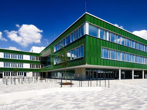 Ein fast fertiggestellter Neubau einer Gesamtschule im Kölner Stadtteil Vogelsang bei sonnigem Wetter im Mai 2024