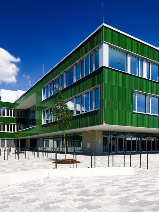 Ein fast fertiggestellter Neubau einer Gesamtschule im Kölner Stadtteil Vogelsang bei sonnigem Wetter im Mai 2024