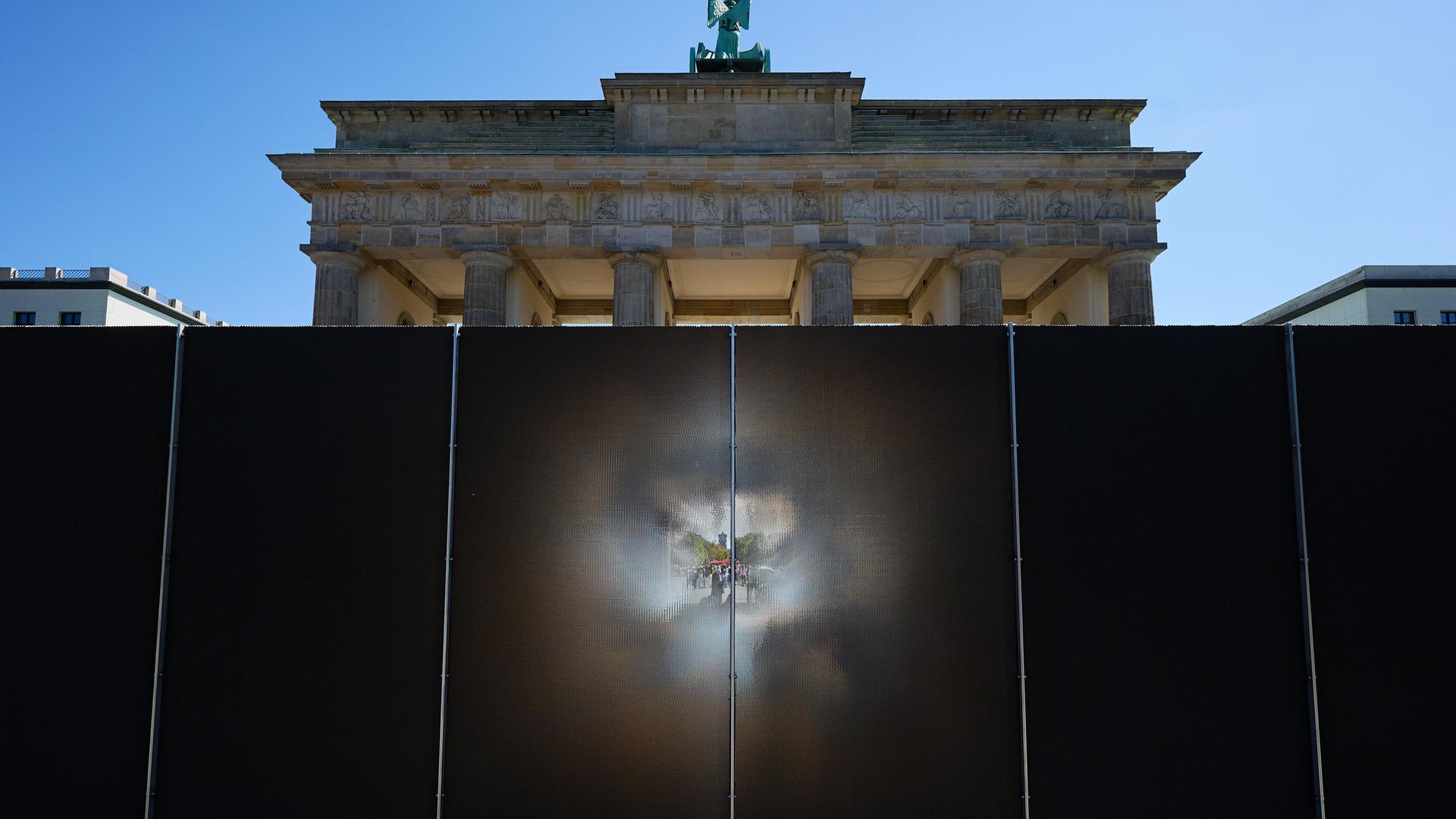 Die rund drei Meter hohe und 30 Meter lange Installation des Künstlers Hubertus Hamm auf dem Platz des 18. März wirkt je nach Perspektive lichtundurchlässig oder transparent. Die rund drei Meter hohe und 30 Meter lange Installation des Künstlers Hubertus Hamm auf dem Platz des 18. März wirkt je nach Perspektive lichtundurchlässig oder transparent.