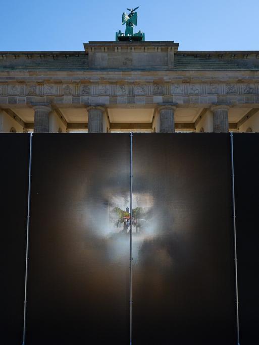 Die rund drei Meter hohe und 30 Meter lange Installation des Künstlers Hubertus Hamm auf dem Platz des 18. März wirkt je nach Perspektive lichtundurchlässig oder transparent. Die rund drei Meter hohe und 30 Meter lange Installation des Künstlers Hubertus Hamm auf dem Platz des 18. März wirkt je nach Perspektive lichtundurchlässig oder transparent.