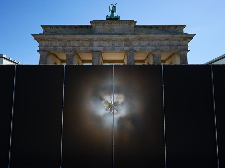 Die rund drei Meter hohe und 30 Meter lange Installation des Künstlers Hubertus Hamm auf dem Platz des 18. März wirkt je nach Perspektive lichtundurchlässig oder transparent. Die rund drei Meter hohe und 30 Meter lange Installation des Künstlers Hubertus Hamm auf dem Platz des 18. März wirkt je nach Perspektive lichtundurchlässig oder transparent.