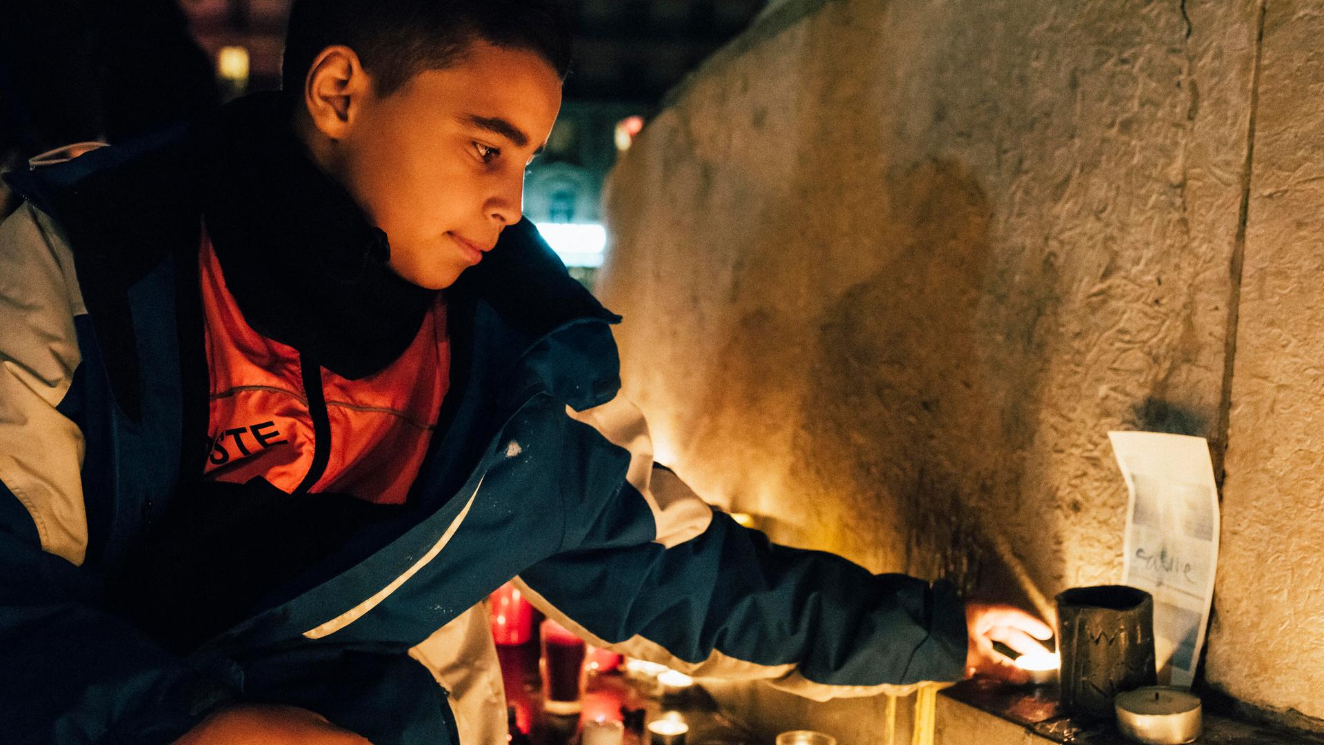 Ein junger Mann zündet eine Kerze an. Ein junger Mann zündet eine Kerze an.
