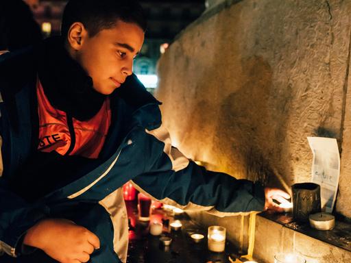 Ein junger Mann zündet eine Kerze an. Ein junger Mann zündet eine Kerze an.