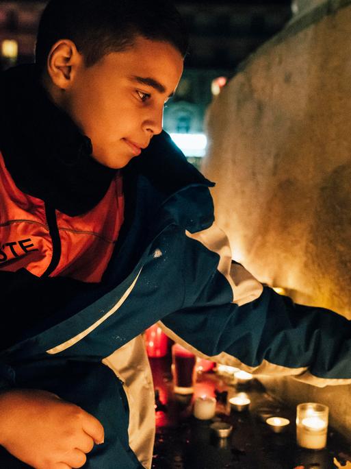 Ein junger Mann zündet eine Kerze an. Ein junger Mann zündet eine Kerze an.