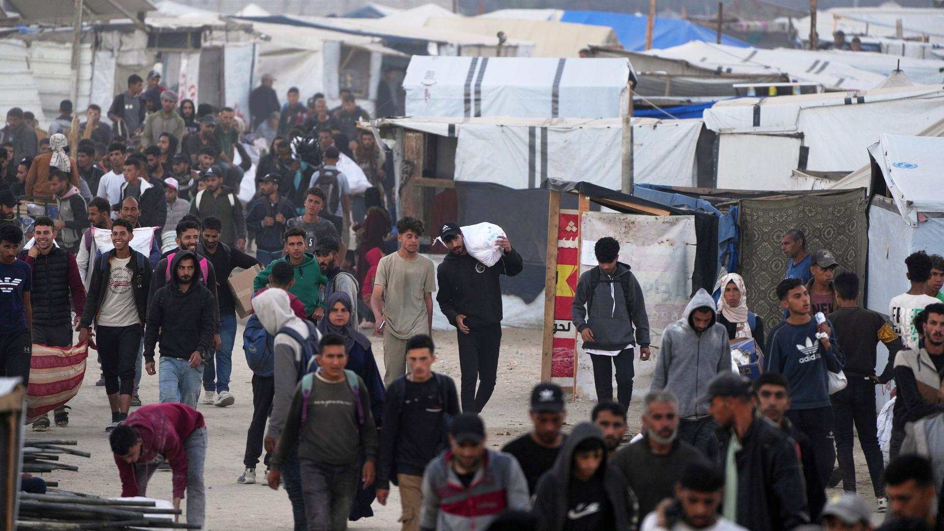 Palästinenser tragen Taschen mit Lebensmitteln und humanitärer Hilfe, die von der Gaza Humanitarian Foundation, einer von Israel anerkannten und von den USA unterstützten Organisation, bereitgestellt wurden. 