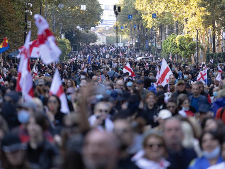 Tausende Menschen demonstrieren auf einer Straße in Tiflis