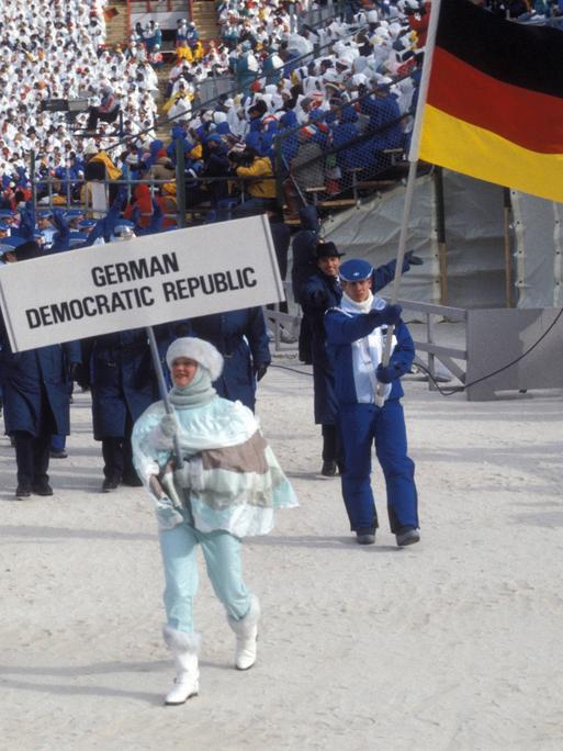 Frank Peter Rötsch (DDR) führt als Fahnenträger die DDR-Olympiamannschaft ins Stadion  