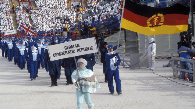 Frank Peter Rötsch (DDR) führt als Fahnenträger die DDR-Olympiamannschaft ins Stadion  