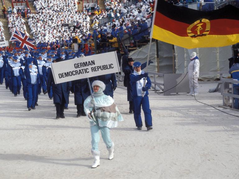 Frank Peter Rötsch (DDR) führt als Fahnenträger die DDR-Olympiamannschaft ins Stadion  