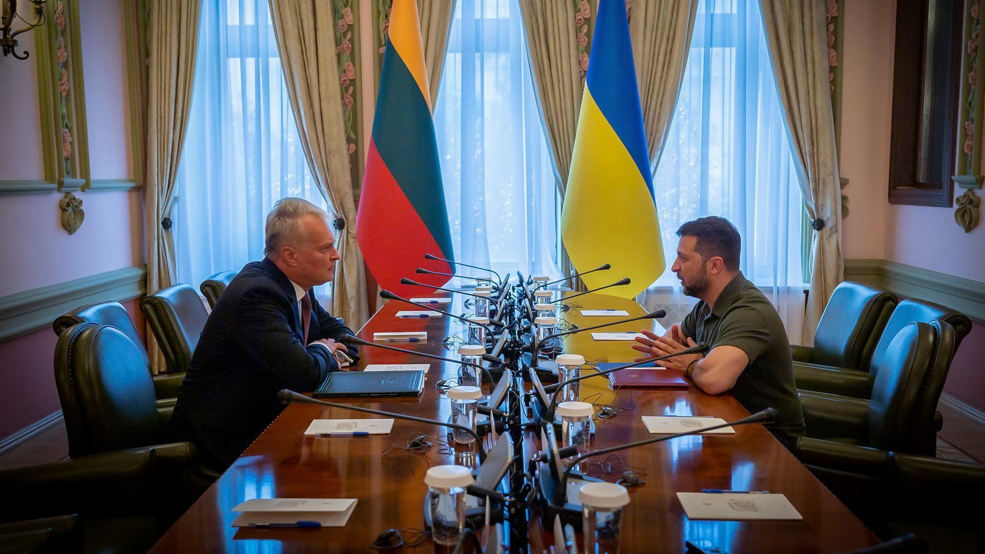 Ukraine, Kiew: Wolodymyr Selenskyj (r), Präsident der Ukraine, und Gitanas Nauseda, Präsident von Litauen sitzen an einem Tisch.