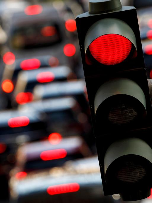 Eine rote Ampel auf der Tunisstraße in Köln, auf der Straße viele Autos mit leuchtendem Rücklicht