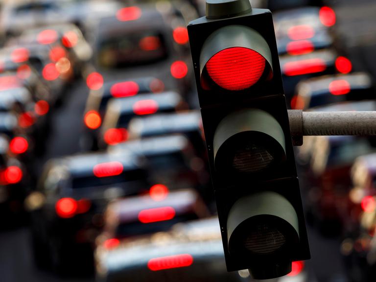 Eine rote Ampel auf der Tunisstraße in Köln, auf der Straße viele Autos mit leuchtendem Rücklicht