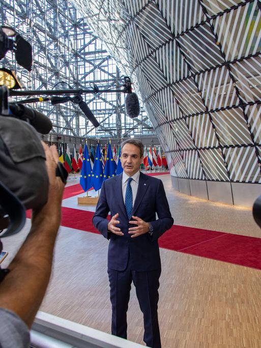 Griechenlands Regierungschef Kyriakos Mitsotakis, hier im Juni bei einem EU-Treffen in Brüssel vor Flaggen der EU und Kameras auf sich gerichtet