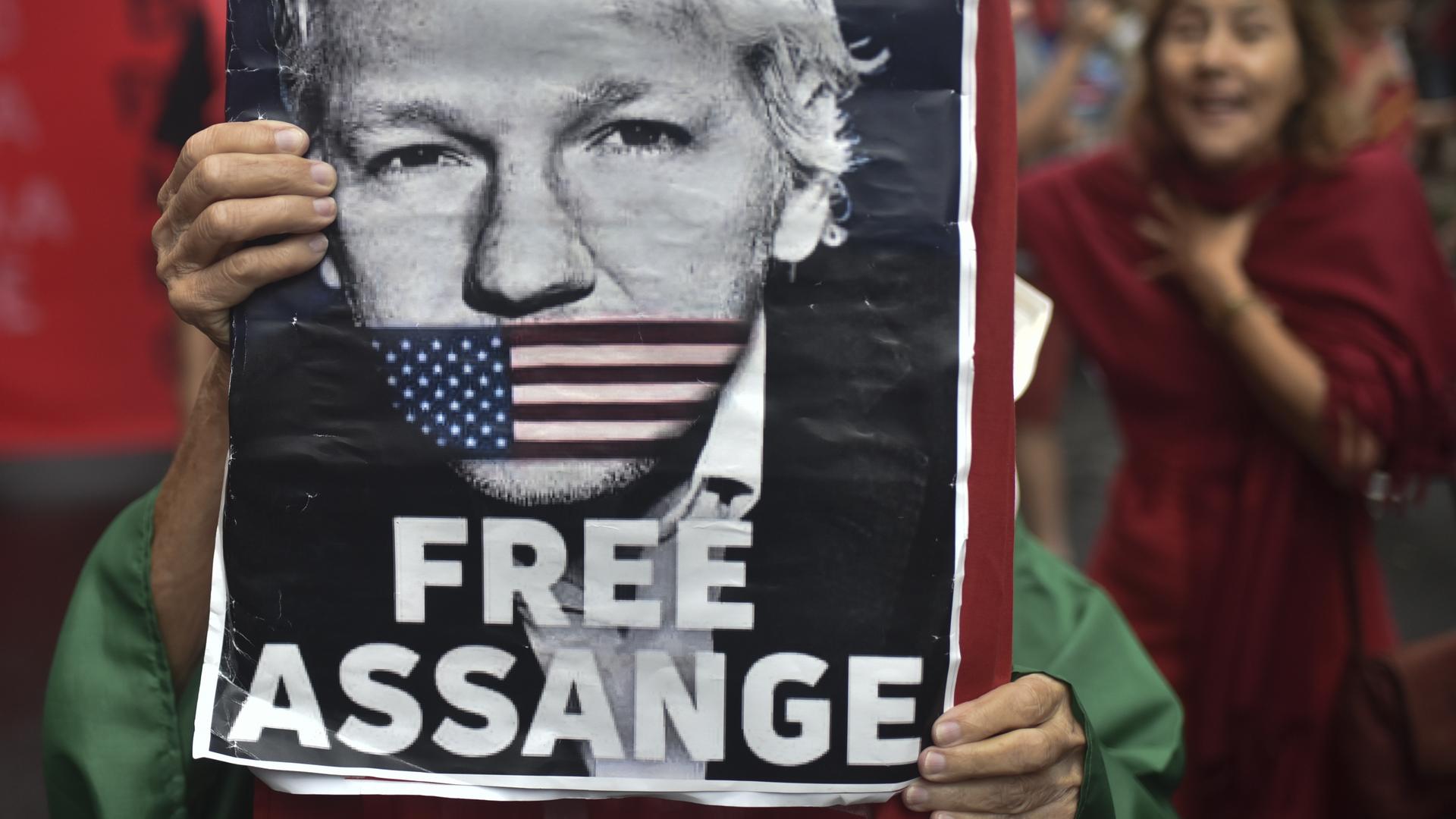 Auf einem Protestmarsch im September 2023 in Rio de Janeiro hält eine Person ein Plakat von Julian Assange hoch.