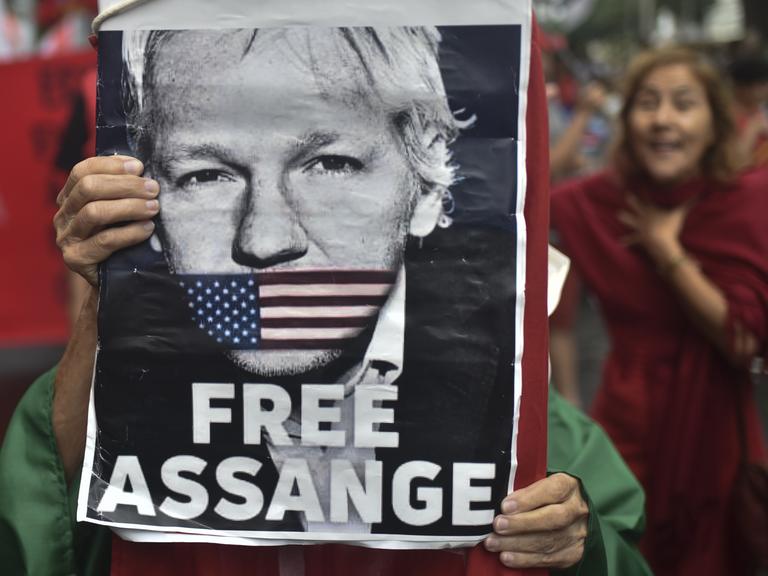 Auf einem Protestmarsch im September 2023 in Rio de Janeiro hält eine Person ein Plakat von Julian Assange hoch.