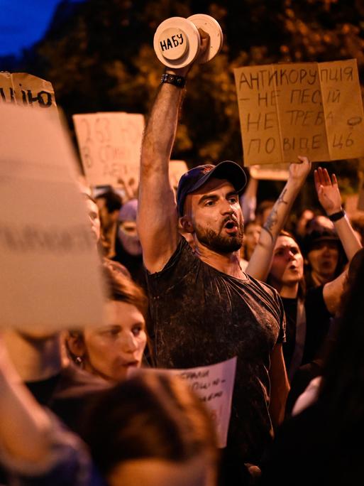 Menschen tragen Schilder und rufen etwas: In Kyiv demonstrieren Menschen gegen das neue Gesetz zur Einschränkung der Antikorruptionsbehörde.