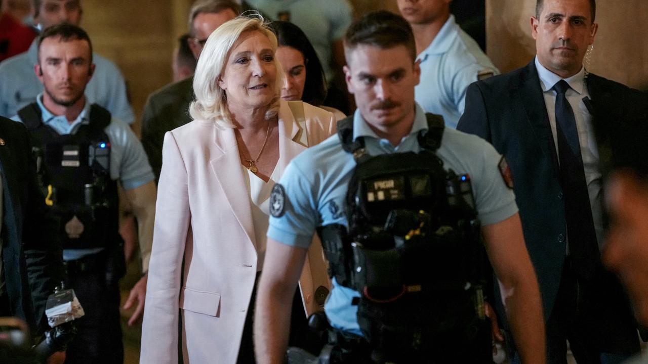 Die Vorsitzende der 'Rassemblement National', Marine Le Pen, verlässt nach der Urteilsverkündung von Veruntreuung europäischer öffentlicher Gelder am 7. Juli 2026 das Pariser Berufungsgericht. Bewaffnete Polizisten laufen vor und hinter ihr.