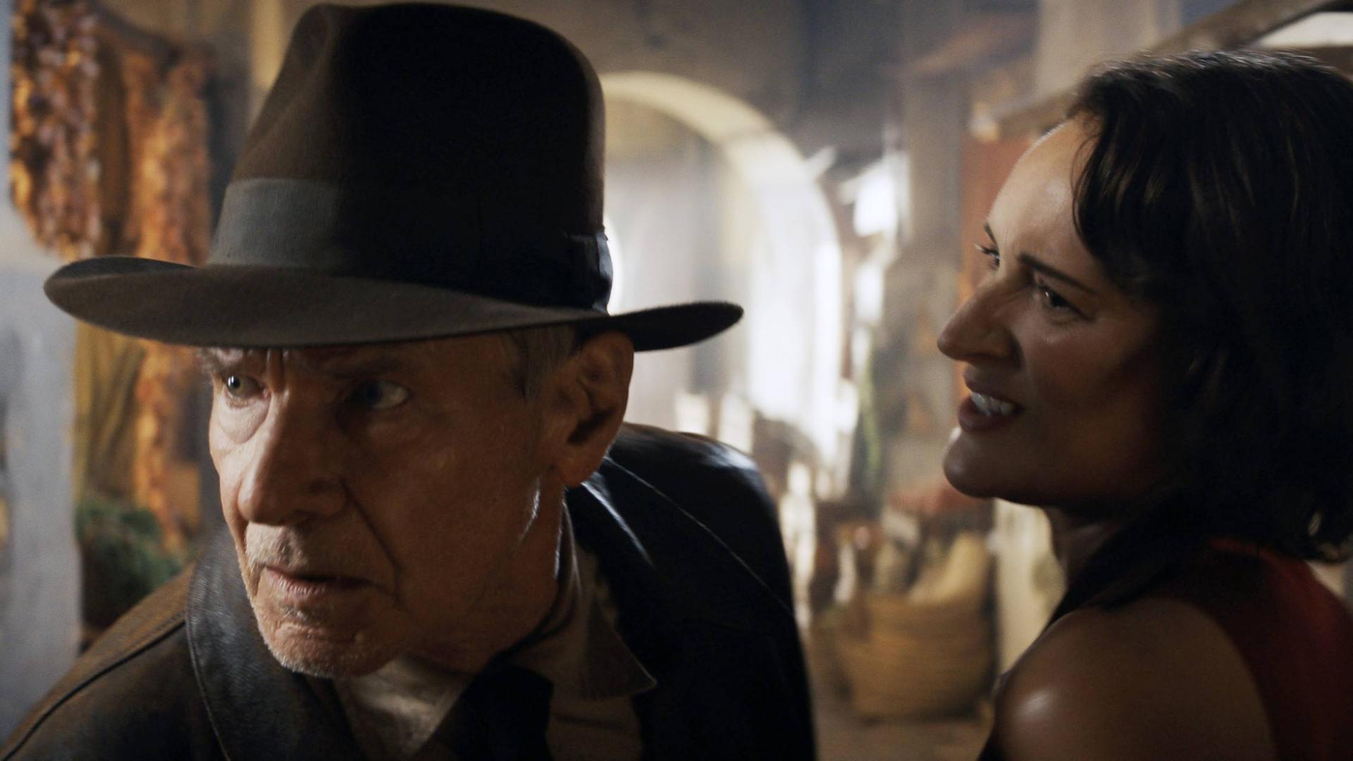Filmszene aus "Indiana Jones und das Rad des Schicksals": Harrison Ford als Indiana Jones sieht hektisch um sich, Phoebe Waller-Bridge als Helena Shaw steht neben ihm.