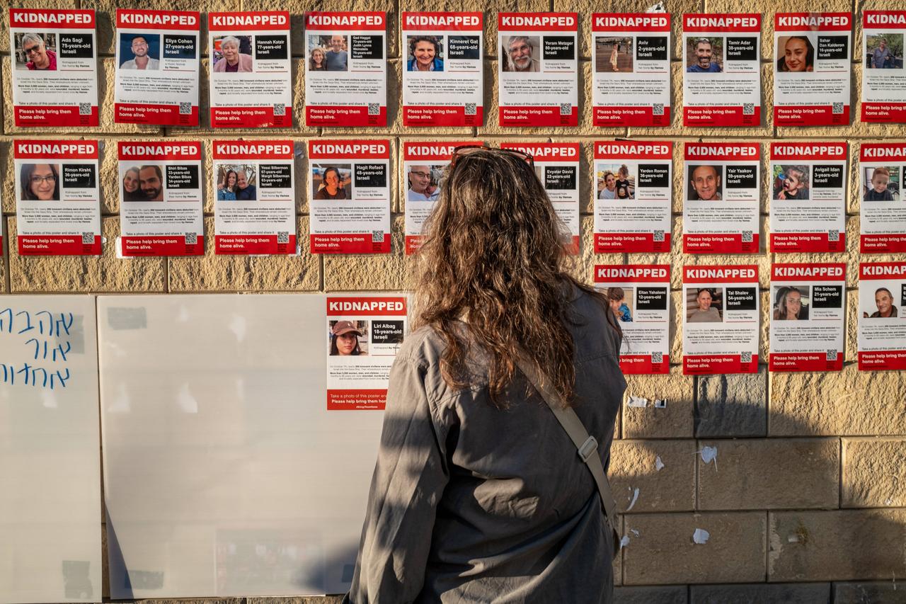 Eine Frau schaut in Tel-Aviv auf Plakate von Geiseln der Hamas.