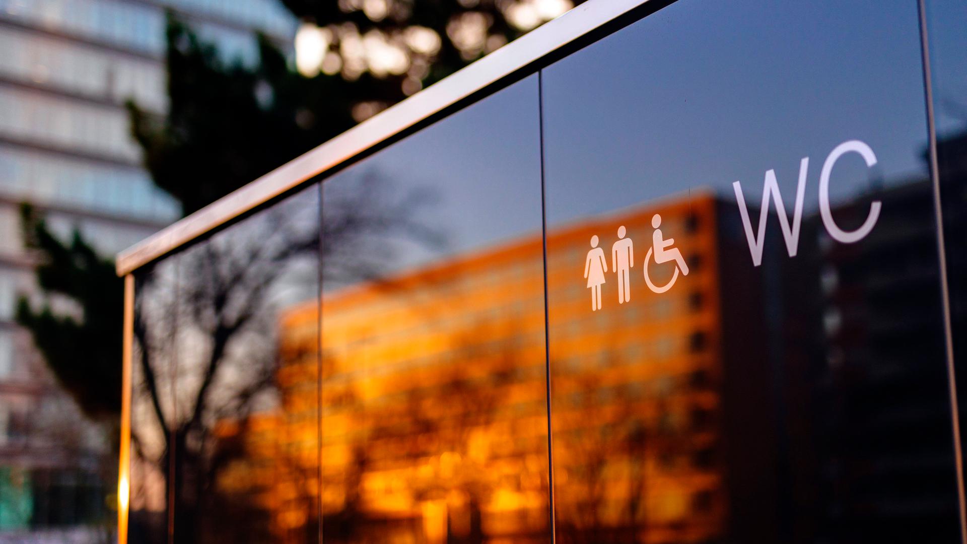 Öffentliche Toilette in Deutz. In der Glasfront des Häuschens spiegelt sich ein gegenüberliegender Wohnblock. Öffentliche Toilette in Deutz. In der Glasfront des Häuschens spiegelt sich ein gegenüberliegender Wohnblock.