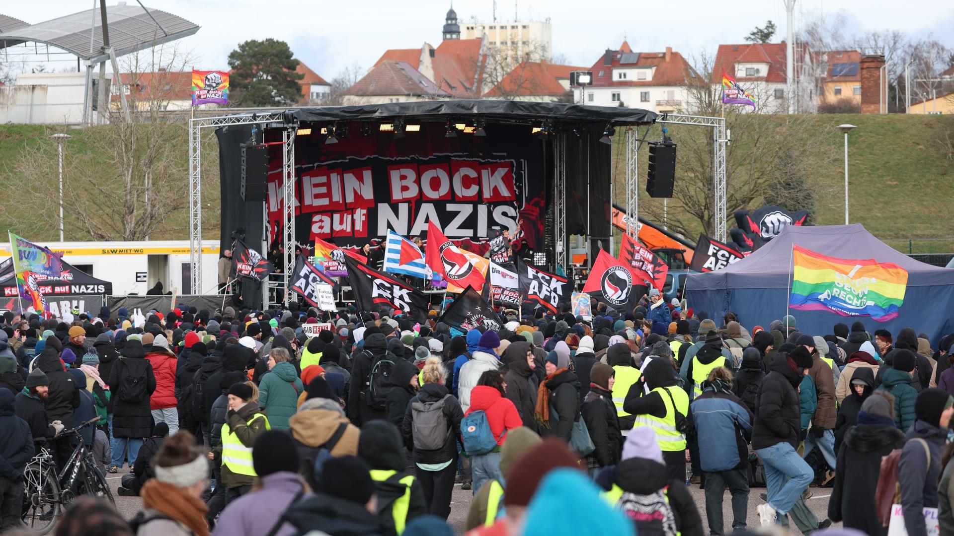 Teilnehmer einer Demonstration gegen den Bundesparteitag der AfD stehen an der Protestbühne vor dem Veranstaltungsort. Auf dem Banner auf der Bühne heißt es "Kein Bock auf Nazis". Teilnehmer einer Demonstration gegen den Bundesparteitag der AfD stehen an der Protestbühne vor dem Veranstaltungsort. Auf dem Banner auf der Bühne heißt es "Kein Bock auf Nazis".