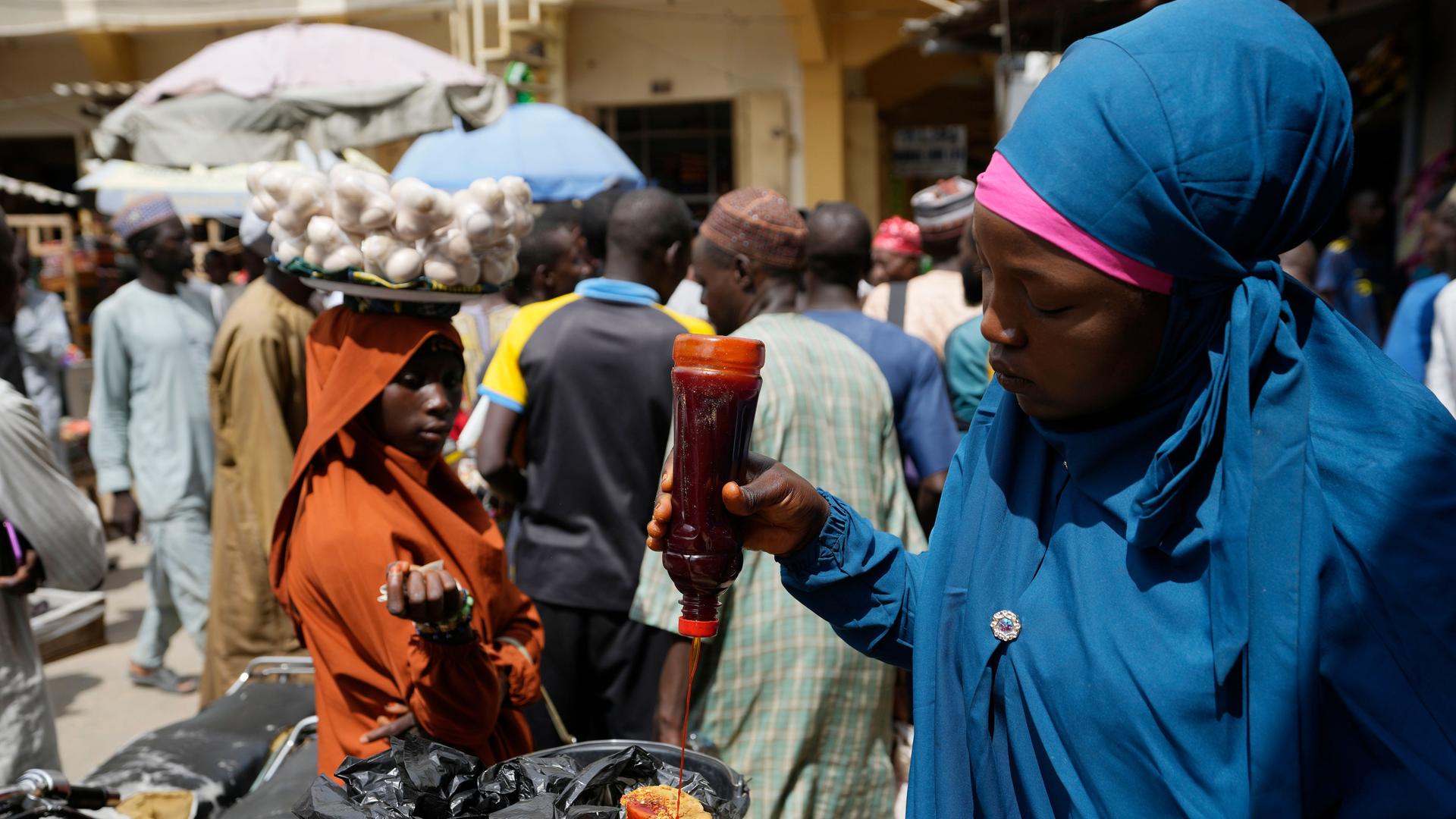 Eine Frau in Nigeria verkauft einheimische Lebensmittel auf einem Markt.