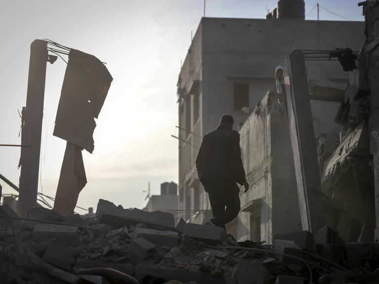 Ein Mann läuft durch eine Ruinenlandschaft in der Flüchtlingscamp Nuseirat im Gazastreifen.