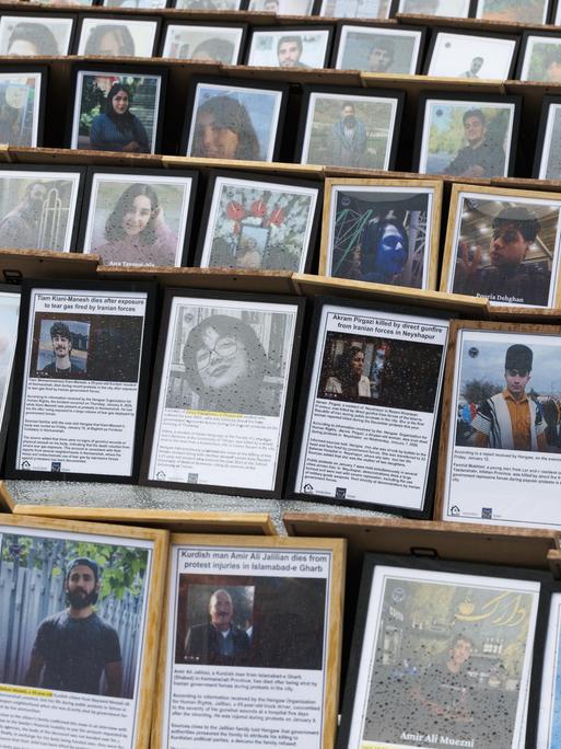 Auf einem Platz sind unzählige Fotos und kurze Texte in Bilderrahmen aufgestellt. Es sind Bilder von den Opfern, die im Zuge der Proteste im Iran ums Leben kamen.