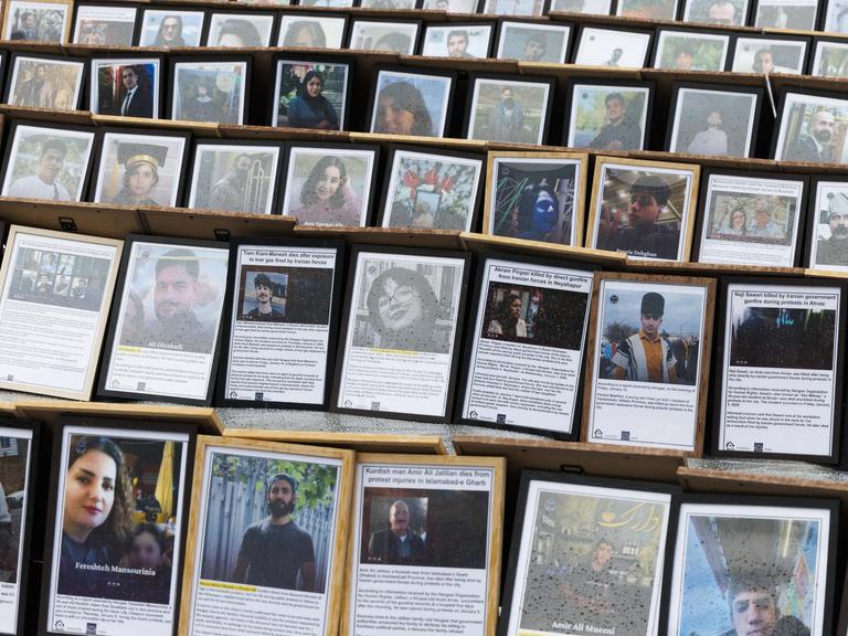 Auf einem Platz sind unzählige Fotos und kurze Texte in Bilderrahmen aufgestellt. Es sind Bilder von den Opfern, die im Zuge der Proteste im Iran ums Leben kamen.