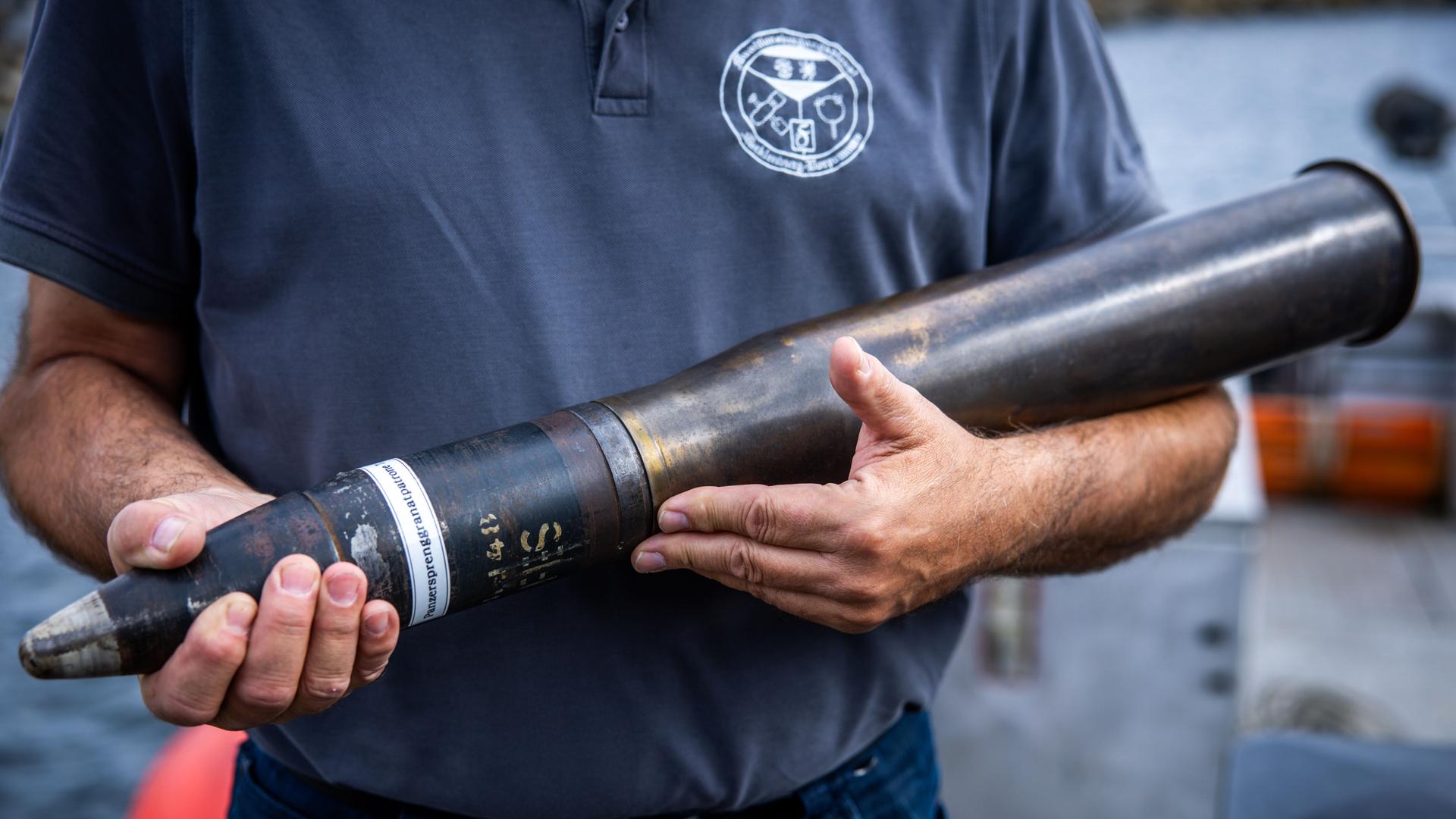 Ein Mitarbeiter des Munitionsbergungsdienst Mecklenburg-Vorpommern zeigt eine 7,5 Zentimeter Panzersprenggranatpatrone. Munition dieser Bauart wird bei der Pilotierungs-Bergung im Rahmen des Sofortprogramms „Munition im Meer“ in der Ostsee gesichert. Ein Mitarbeiter des Munitionsbergungsdienst Mecklenburg-Vorpommern zeigt eine 7,5 Zentimeter Panzersprenggranatpatrone. Munition dieser Bauart wird bei der Pilotierungs-Bergung im Rahmen des Sofortprogramms „Munition im Meer“ in der Ostsee gesichert.