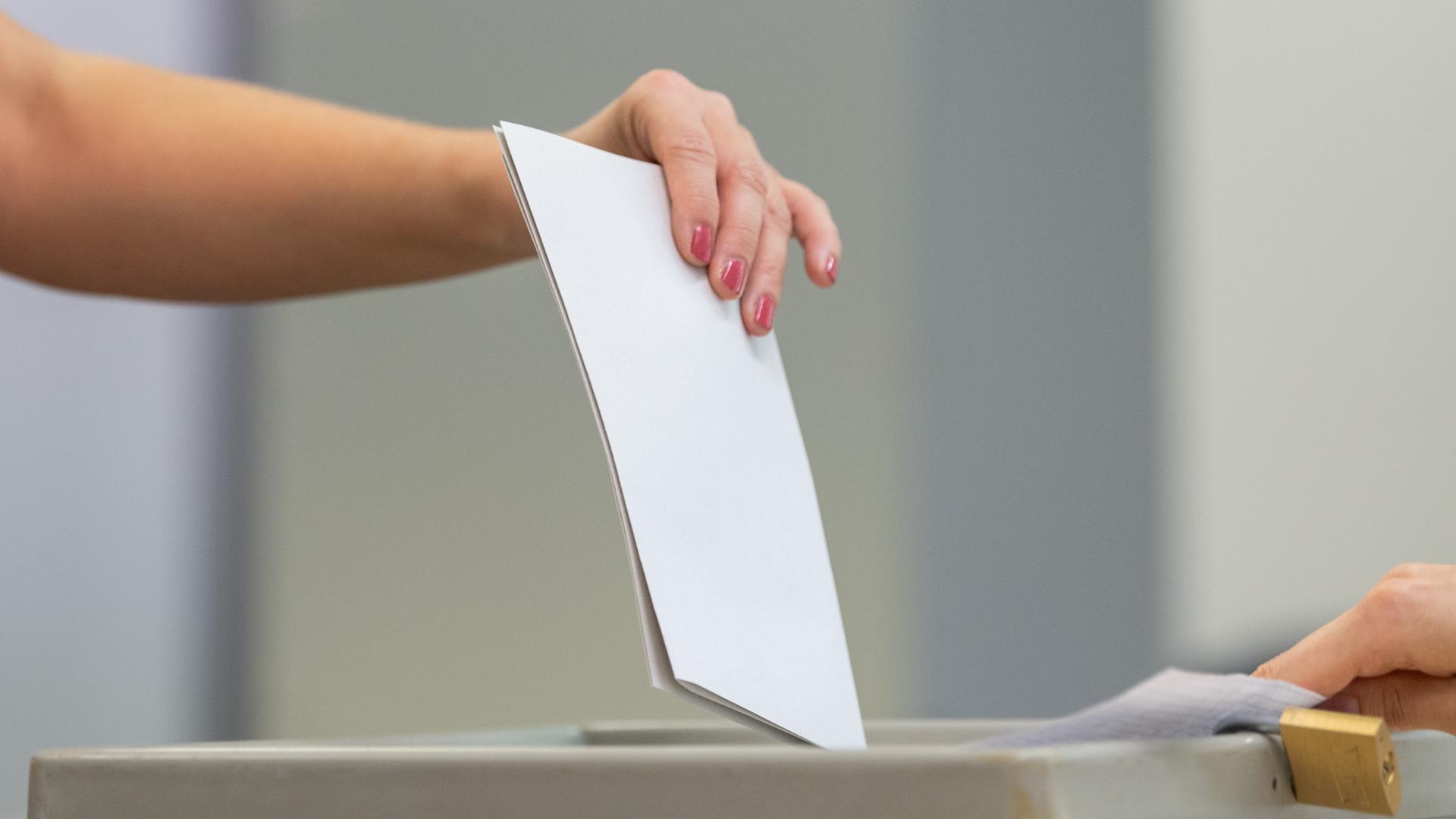 Eine Wählerin wirft bei der Stimmabgabe zu einer Landtagswahl den Wahlzettel in einem Wahllokal in eine Wahlurne.