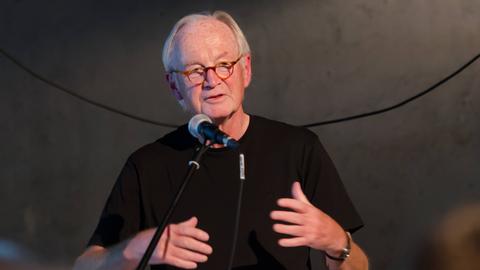 Soziologe Wilhelm Heitmeyer spricht vor dunklem Hintergrund bei einer Ringvorlesung in Flensburg am 28.10.2019